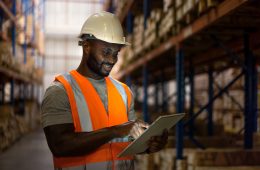 Warehouse worker on duty. Warehouse worker using digital tablet to check inventory in storage room.