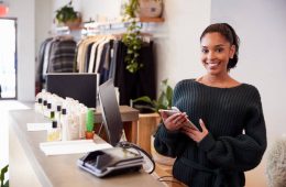 Female assistant smiling from the counter in clothing store Female assistant smiling from the counter in clothing store